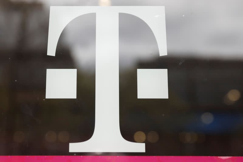 A T-Mobile logo is seen on the storefront door of a store in Manhattan