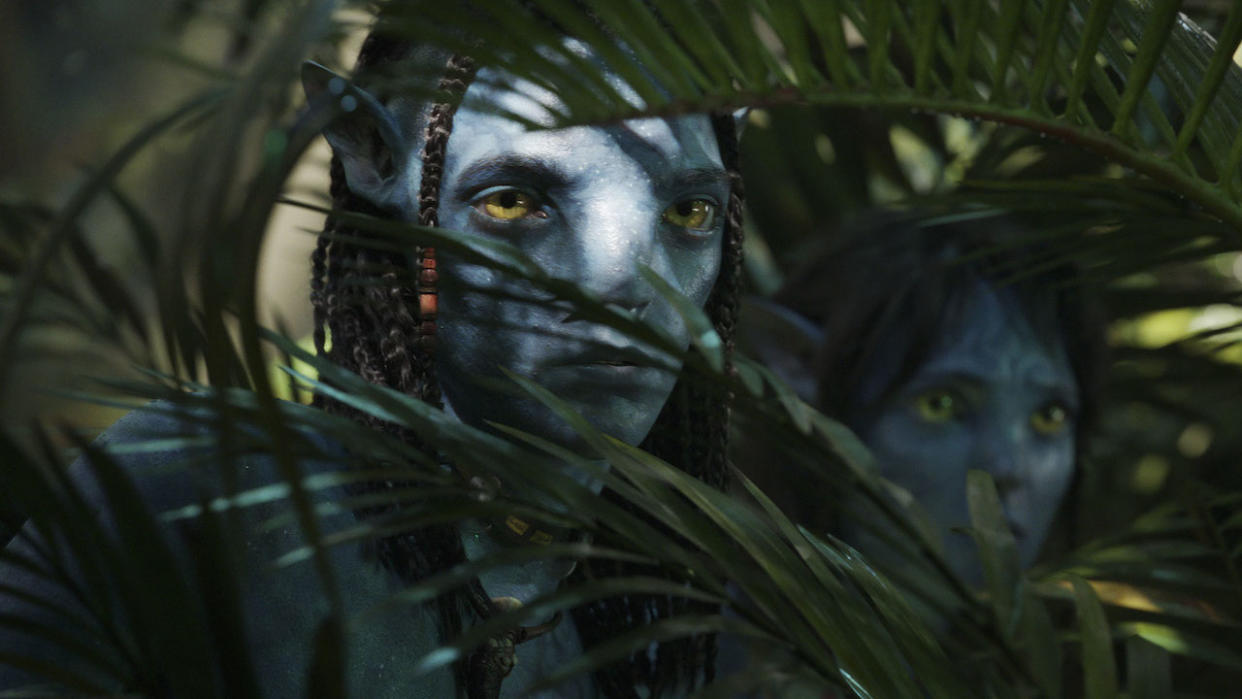  Jake Sully peering through plants in Avatar: The Way of Water. 