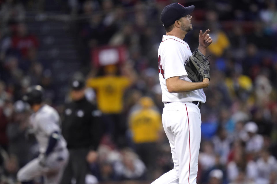 Boston Red Sox starting pitcher Rich Hill, right, heads back to the mound after giving up a three-run home run to Seattle Mariners' Dylan Moore, left, during the second inning of a baseball game against the Boston Red Sox at Fenway Park, Thursday, May 19, 2022, in Boston. (AP Photo/Charles Krupa)