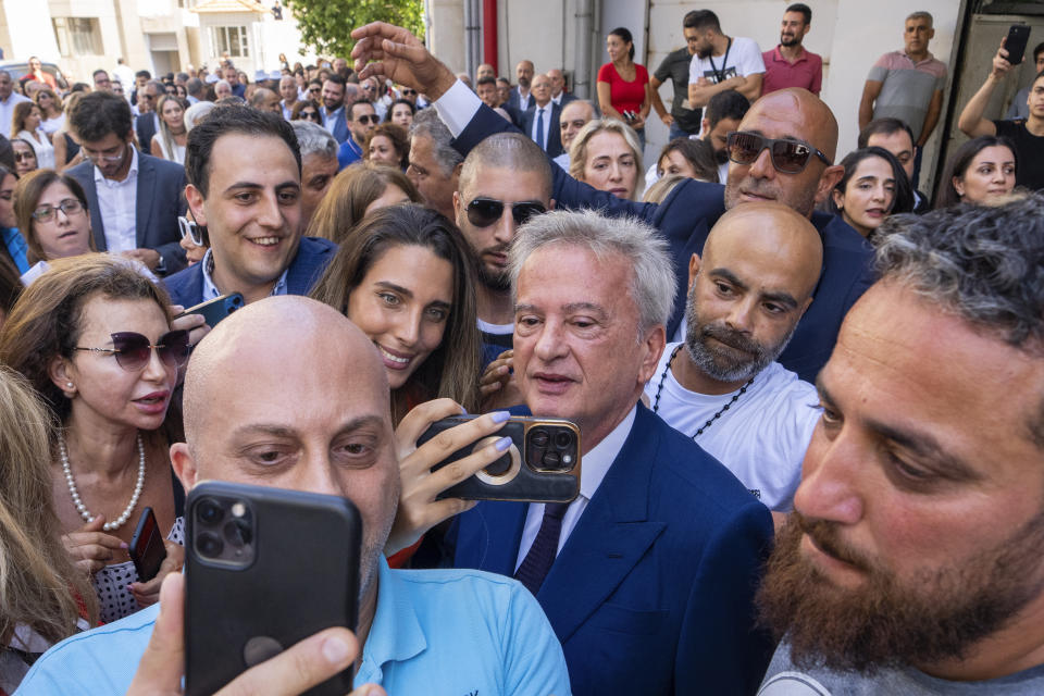 Riad Salameh, center, Lebanon's outgoing Central Bank governor, greets employees at a farewell party marking the end of his 30 years in office outside the Lebanese Central Bank building, in Beirut, Monday, July 31, 2023. Lebanon's embattled central bank governor Monday ended his 30-year tenure. Meanwhile, his four vice governors, led by incoming interim governor Wassim Mansouri, urged the cash-strapped country's government for fiscal reforms at a news conference in that same building. (AP Photo/Hassan Ammar)