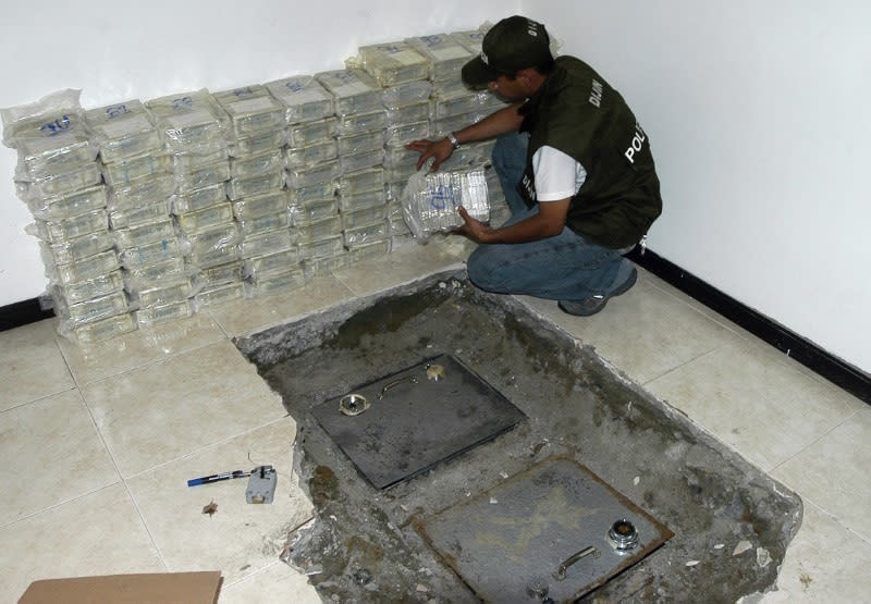 Foto de archivo. Un policía cuenta paquetes de billetes de dólares estadounidenses presuntamente de actividades de narcotráfico encontrados durante una redada en Cali