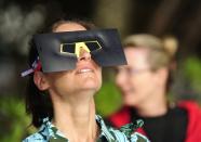 PALM COVE, AUSTRALIA - NOVEMBER 14: A spectator views the solar eclipse through special eclipse viewing glasses on November 14, 2012 in Palm Cove, Australia. Thousands of eclipse-watchers have gathered in part of North Queensland to enjoy the solar eclipse, the first in Australia in a decade. (Photo by Ian Hitchcock/Getty Images)