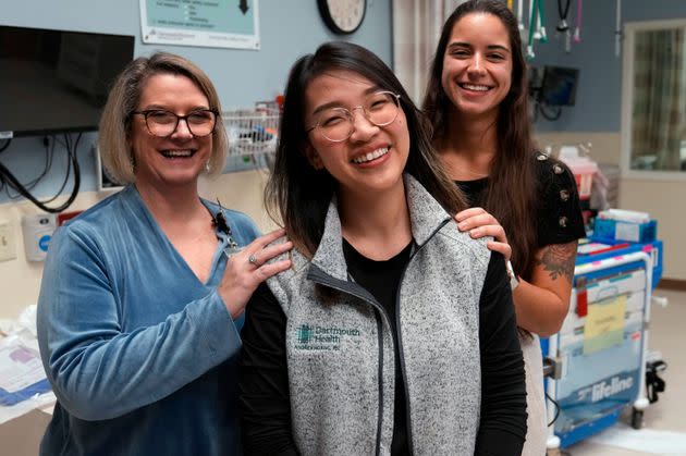 Andy Hoang, a recent nursing graduate, center, poses with co-workers Lisa Davenport, left, and Justina Terino at the spot where she was stricken during a cardiac training session.