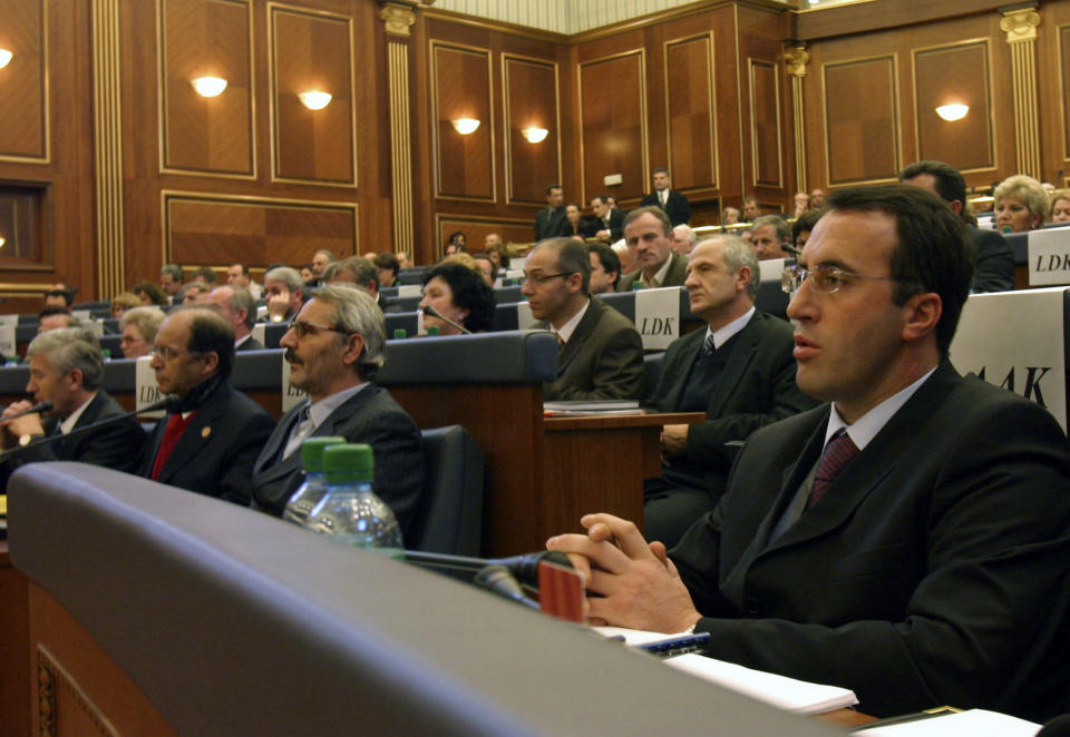 FILE - In this Friday, Dec. 3, 2004 file photo, Ramush Haradinaj, right, former rebel commander elected Kosovo's Prime Minister, listens during the inaugural session of Kosovo's parliament in Kosovo's capital Pristina. Kosovo’s prime minister has resigned from the post after he has been invited to be questioned from a European Union-funded court investigating crimes against ethnic Serbs during and after the 1998-99 independence war with Serbia. Haradinaj said on Friday, July 19, 2019 he had informed the Cabinet of his resignation and urged the country’s president to set a date for an early parliamentary election. (AP Photo / Visar Kryeziu)