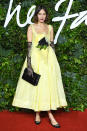 <p>in a romantic, yellow Caroline Hu design with a flower accent at the waist, plus black lace gloves. </p>