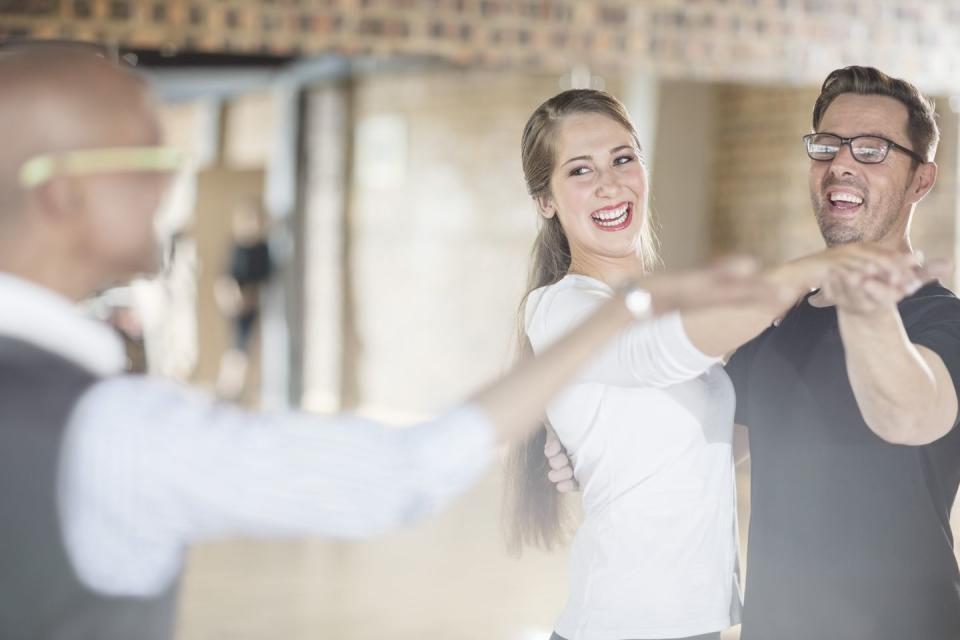 smiling dance partners together in dance class with instructor