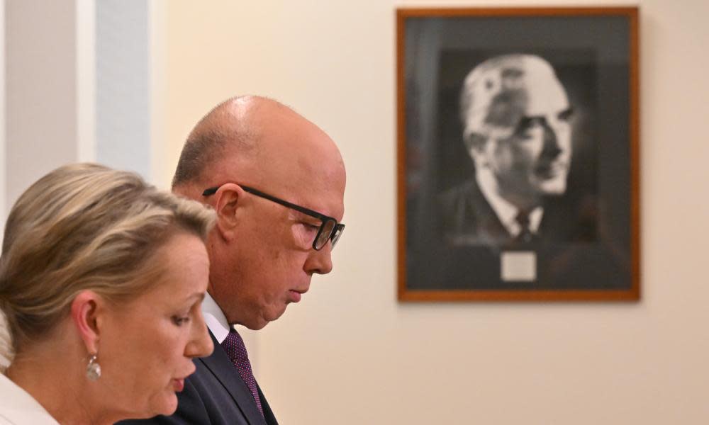 Peter Dutton and Sussan Ley seen from the side with a photograph of Gough Whitlam seen on the wall behind.