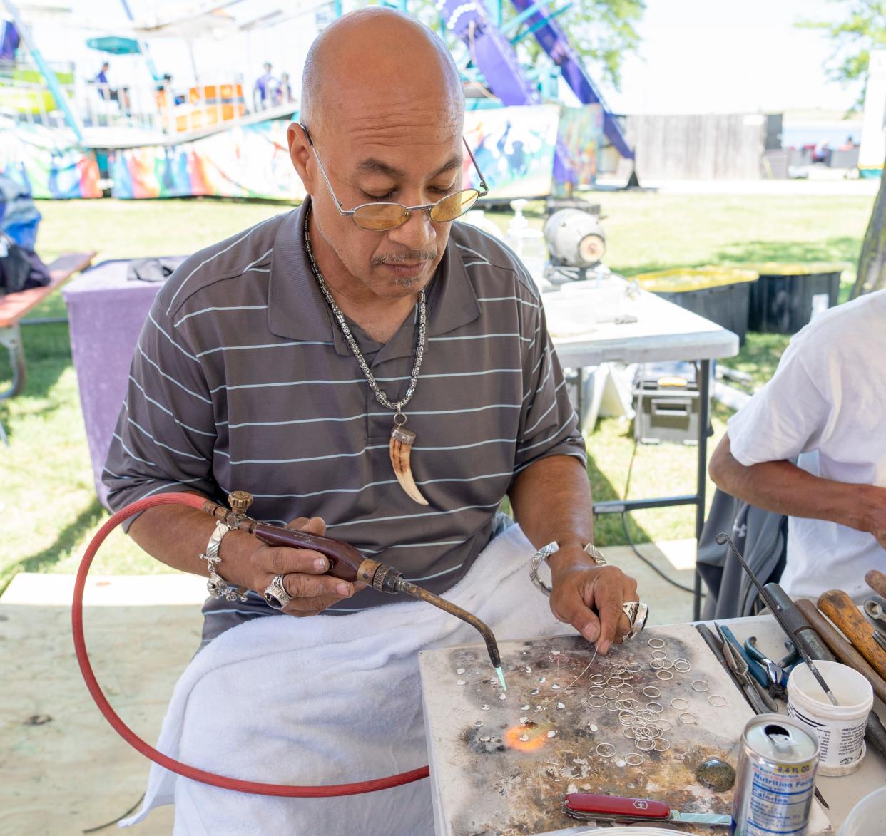 Manuel Corona Sr., owner of Khepra Jewelers, makes one-of-a-kind rings at his stand in Summerfest on Thursday, June 23, 2022 at the Henry Maier Festival Park in Milwaukee.