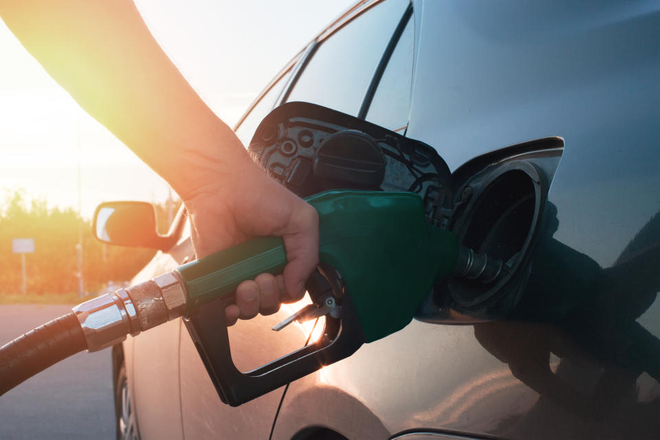 hand guiding the fuel in the gasoline tank of the car at a small depth of field