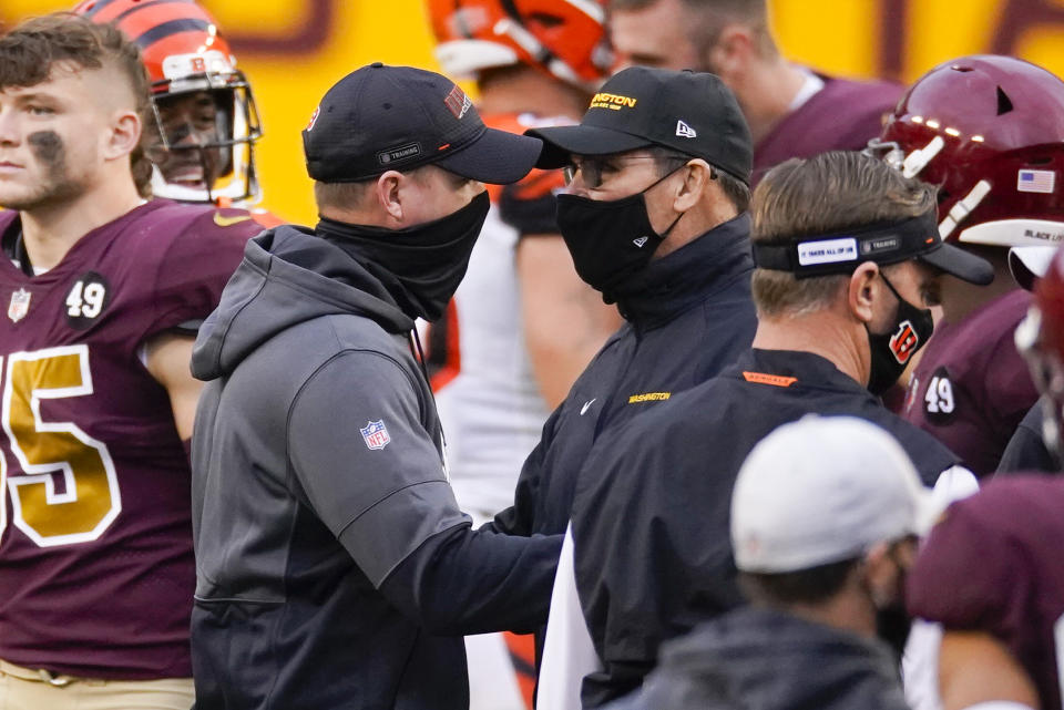 Cincinnati Bengals head coach Zac Taylor, left, and Washington Football Team head coach Ron Rivera, right, greet each other on the field at the end of an NFL football game between the Cincinnati Bengals and Washington Football Team, Sunday, Nov. 22, 2020, in Landover, Md. Washington won 20-9. (AP Photo/Al Drago)