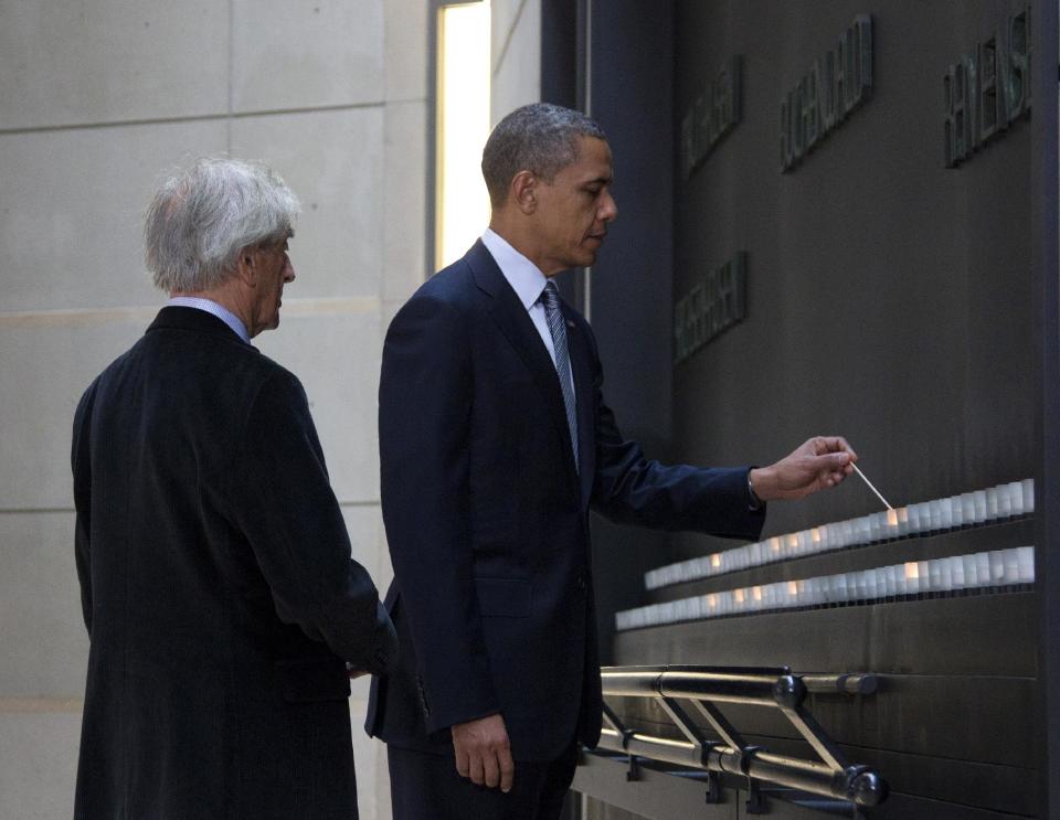 President Barack Obama, accompanied by Nobel Peace Prize laureate and Holocaust survivor Elie Wiesel, light candles in the Hall of Remembrance as they toured the Holocaust Memorial Museum in Washington, Monday, April 23, 2012. (AP Photo/Carolyn Kaster)