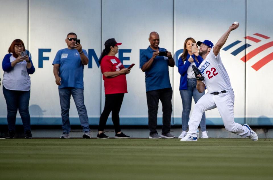 Clayton Kershaw warms up in front of a small group of fans near the outfield wall before Saturday's game against the Giants.