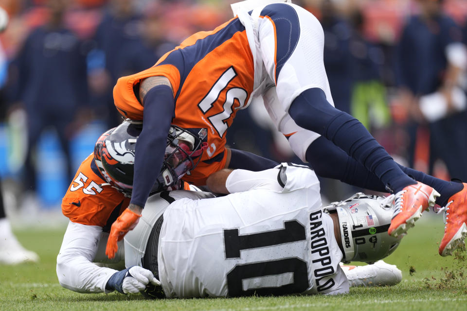 Denver Broncos safety Justin Simmons (31) and Broncos linebacker Frank Clark (55) tackle Las Vegas Raiders quarterback Jimmy Garoppolo (10) during the first half of an NFL football game, Sunday, Sept. 10, 2023, in Denver. (AP Photo/David Zalubowski)