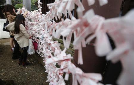 Visitors hang fortune blessing papers at Yasukuni Shrine in Tokyo December 26, 2013. REUTERS/Yuya Shino