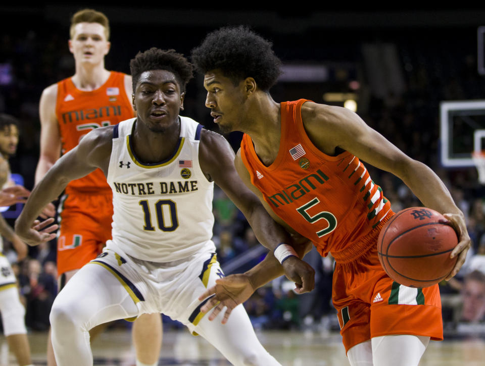 Miami's Harlond Beverly (5) drives in next to Notre Dame's Temple 'T.J.' Gibbs (10) during the first half of an NCAA college basketball game Sunday, Feb. 23, 2020, in South Bend, Ind. (AP Photo/Robert Franklin)