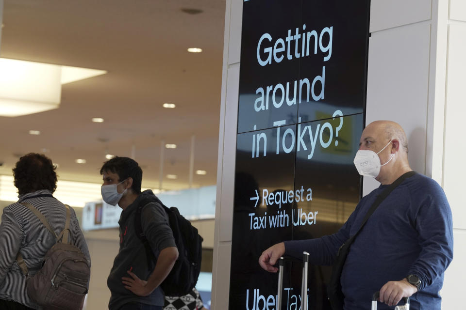 Foreign travelers arrive at the Haneda International Airport Tuesday, Oct. 11, 2022, in Tokyo. Japan's strict border restrictions are eased, allowing tourists to easily enter for the first time since the start of the COVID-19 pandemic. Independent tourists are again welcomed, not just those traveling with authorized groups. (AP Photo/Eugene Hoshiko)
