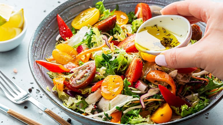 pouring dressing on a salad