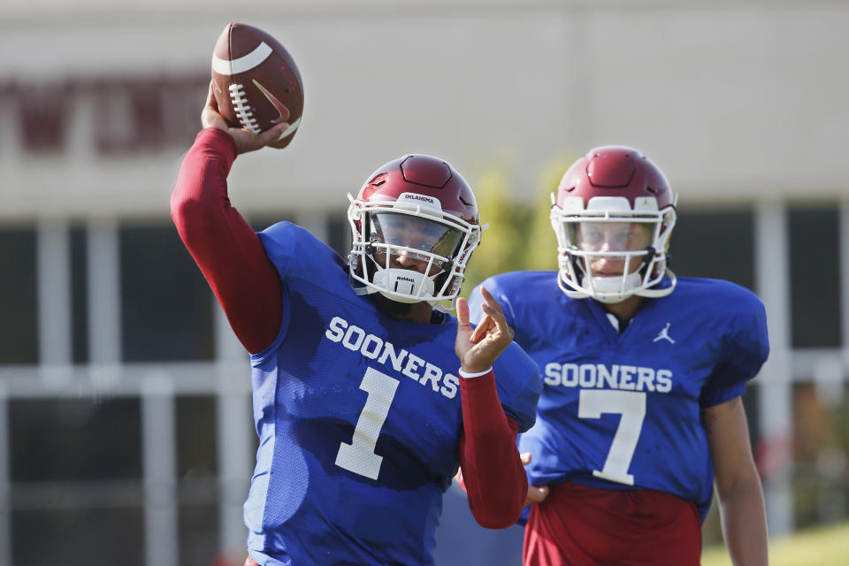 FILE - In this Monday, Aug. 5, 2019, file photo, Oklahoma quarterback Jalen Hurts (1) throws as quarterback Spencer Rattler watches during the NCAA college football team's practice in Norman, Okla. Oklahoma coach Lincoln Riley has chosen Hurts as his starting quarterback for the Sept. 1 season opener against Houston over Rattler and Tanner Mordecai. (AP Photo/Sue Ogrocki, File)