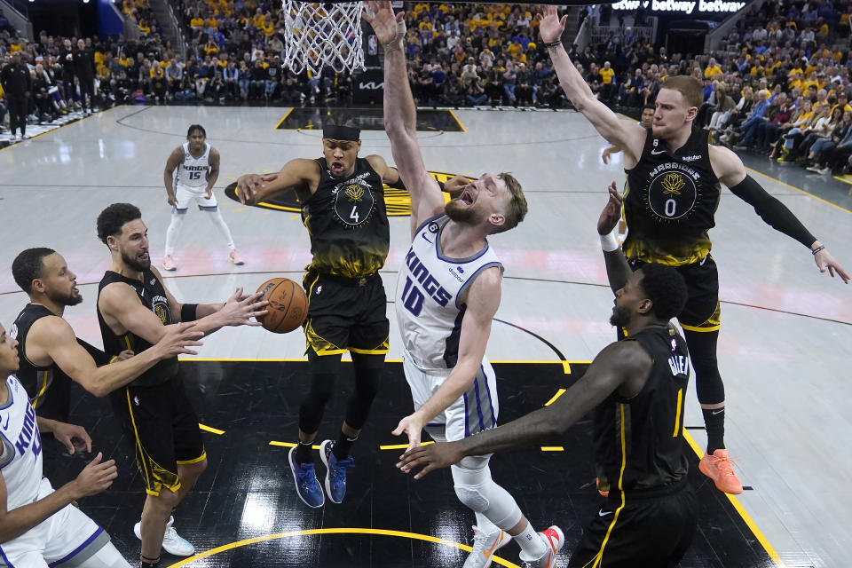 Sacramento Kings forward Domantas Sabonis (10) loses the ball between Golden State Warriors guard Stephen Curry, left, guard Klay Thompson, second from left, guard Moses Moody (4), guard Donte DiVincenzo (0) and forward JaMychal Green (1) during the second half of Game 3 of an NBA basketball first-round playoff series in San Francisco, Thursday, April 20, 2023. (AP Photo/Jeff Chiu)