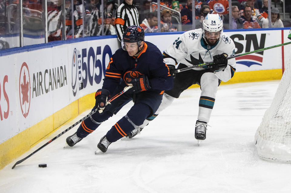 San Jose Sharks' Jaycob Megna (24) and Edmonton Oilers' Zach Hyman (18) battle for the puck during second-period NHL hockey game action in Edmonton, Alberts, Thursday, April 28, 2022. (Jason Franson/The Canadian Press via AP)