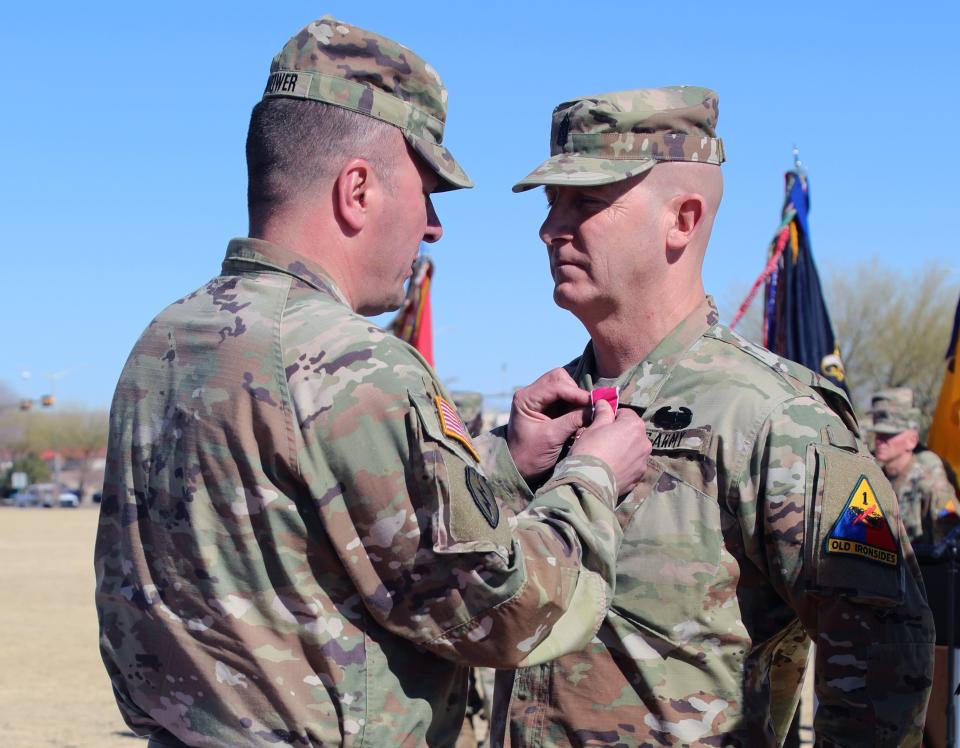 The outgoing 1st Armored Division's Command Sgt. Maj. Michael C. Williams receives his retirement award from the 1st Armored Division commanding general, Maj. Gen. James P. Isenhower III at Fort Bliss, Texas, March 3, 2023. (Staff Sgt. Jesse Anderla/Army)