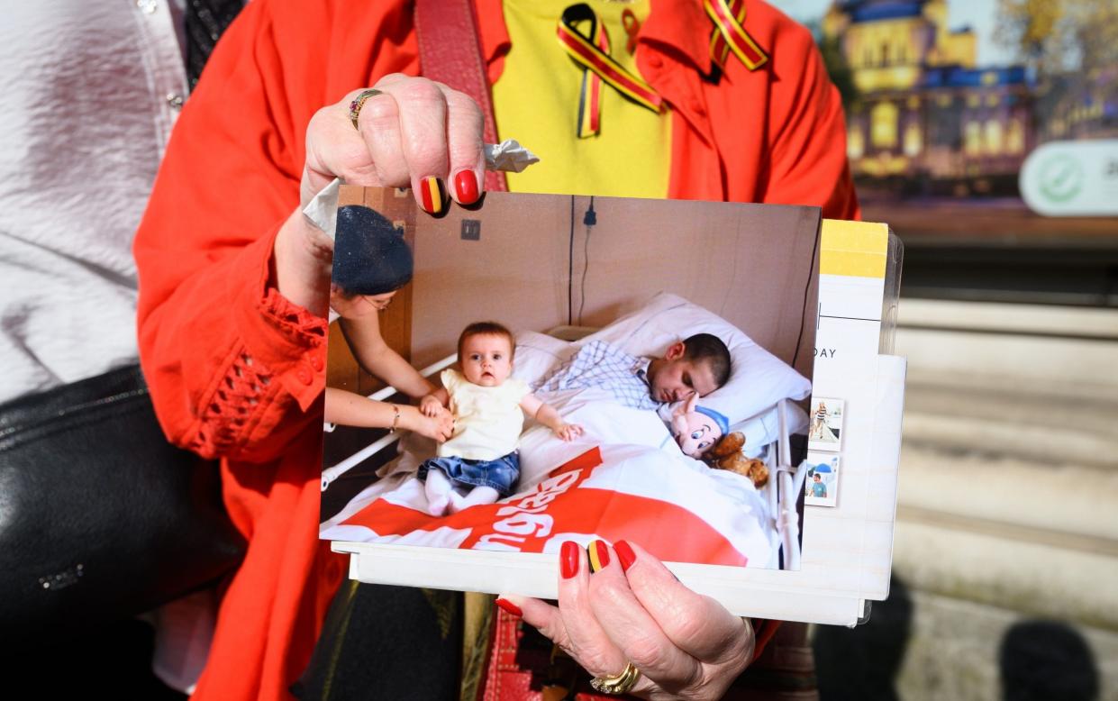 A woman olds a photograph of Marc Payton, who died in 2003 after being mistakenly infected with HIV and Hepatitis-C while in a children's hospita