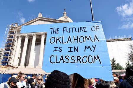 FILE PHOTO: Teachers rally outside the state Capitol on the second day of a teacher walkout to demand higher pay and more funding for education in Oklahoma City, Oklahoma, U.S., April 3, 2018. REUTERS/Nick Oxford/File Photo