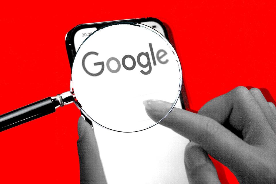 A magnifying glass over someone's finger as they tap the Google search bar on a smartphone.