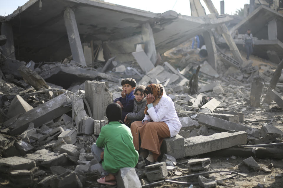 Palestinians sit by the destruction from the Israeli bombardment of the Gaza Strip in Rafah on Monday, Feb. 12, 2024. (AP Photo/Hatem Ali)