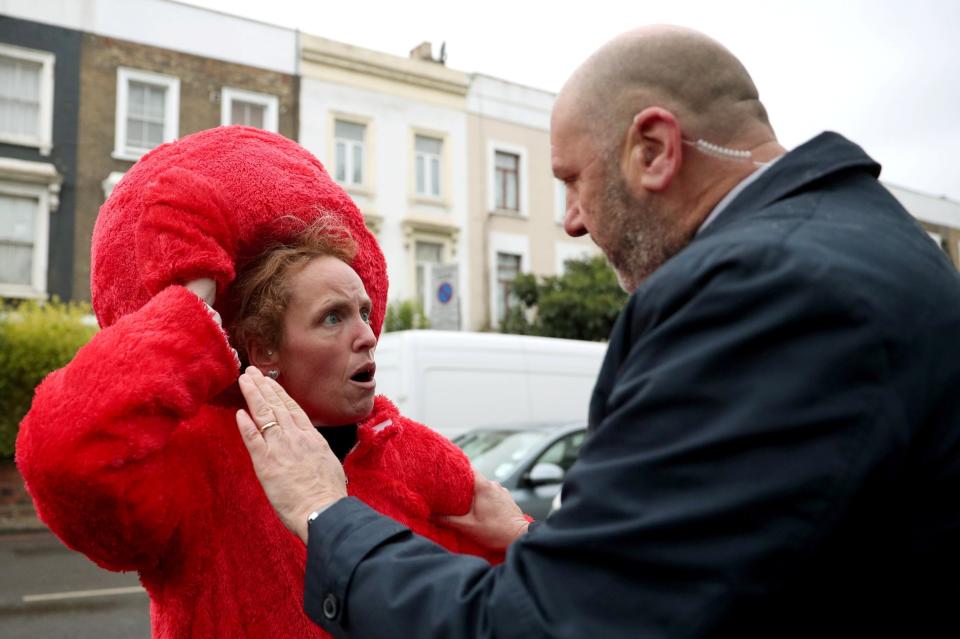 A member of Britain's opposition Labour Party leader Jeremy Corbyn's security detail argues with a protester dressed as Sesame Street character Elmo (REUTERS)