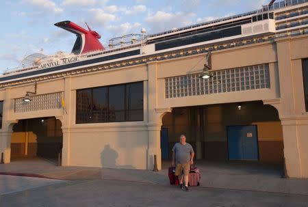 A passenger disembarks from the Carnival Magic cruise ship after it reached port in Galveston, Texas October 19, 2014. REUTERS/Daniel Kramer