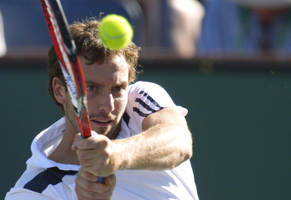 Ernests Gulbis, of Latvia, hits to John Isner during their quarterfinal match at the BNP Paribas Open tennis tournament on Friday, March 14, 2014, in Indian Wells, Calif. (AP Photo/Mark J. Terrill)