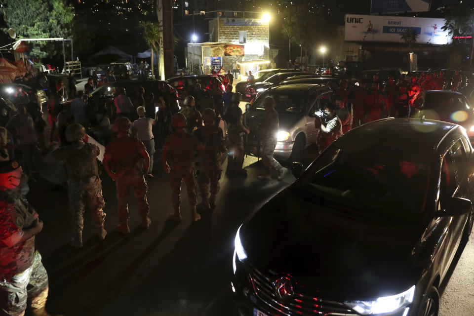 Lebanese army soldiers try to open a main highway blocked by anti-government protesters during a demonstration against deteriorating economic conditions as politicians are deadlocked over forming a new government, in the town of Jal el-Dib, north of Beirut, Lebanon, Sunday, Sept. 27, 2020. Lebanese Prime Minister-designate Mustapha Adib resigned Saturday amid a political impasse over government formation, dealing a blow to French President Emmanuel Macron's efforts to break a dangerous stalemate in the crisis-hit country. (AP Photo/Bilal Hussein)