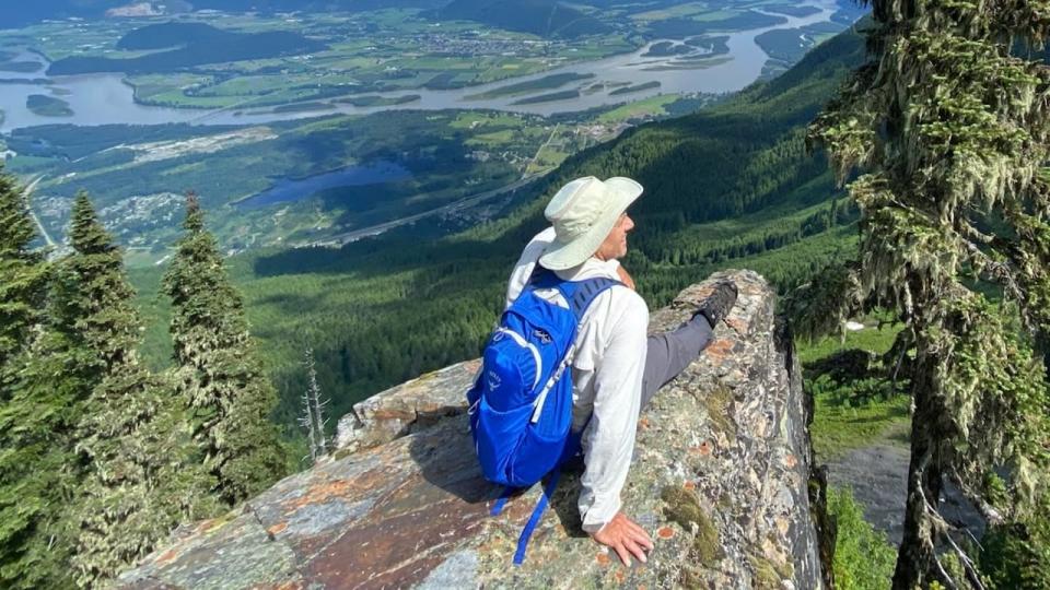 A man is seen sitting on a rock in the area where the Cascade Skyline Gondola Project would be built above the Fraser Valley in this promotional image from the project's website.