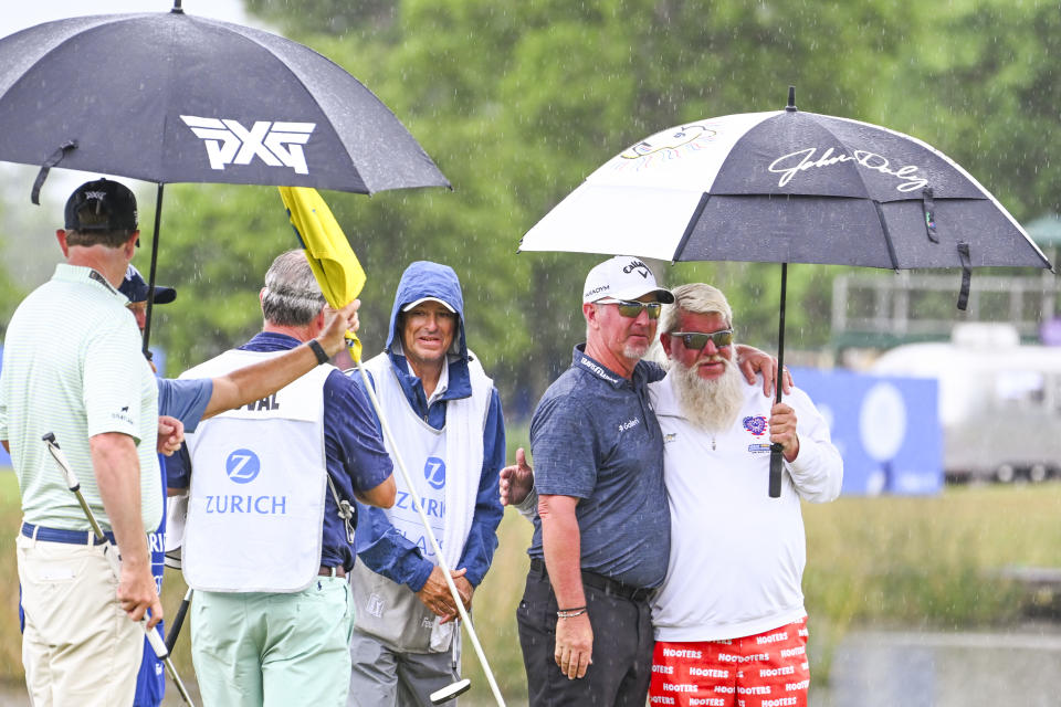 Duval and Daly huddle under an umbrella