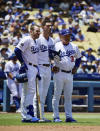 Los Angeles Dodgers Max Muncy, left, stand with Cody Bellinger, center, and manager Dave Roberts after Bellinger hit a fan with a foul ball during the first inning of a baseball game against the Colorado Rockies Sunday, June 23, 2019, in Los Angeles. (AP Photo/Mark J. Terrill)
