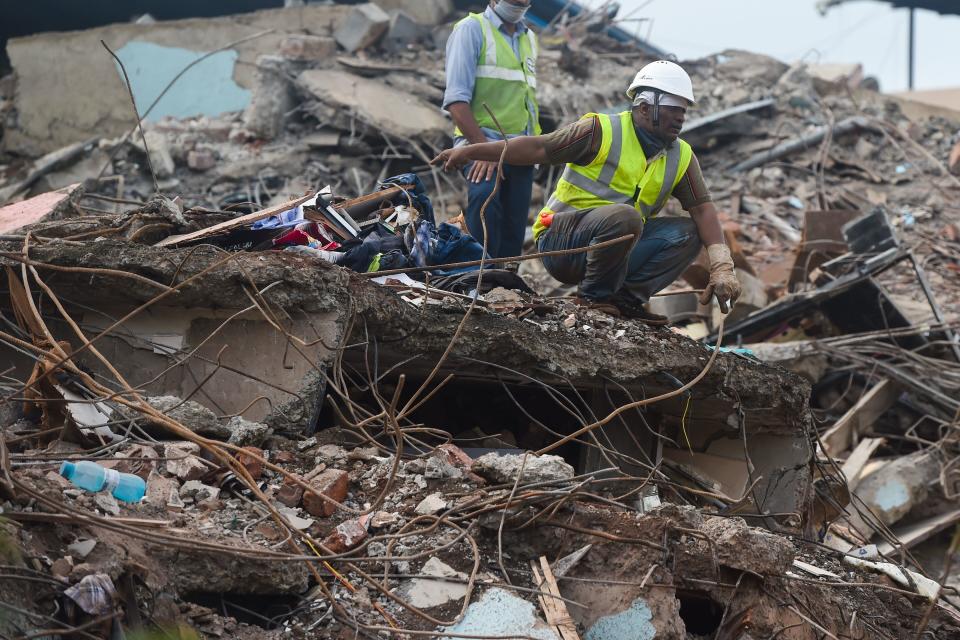 Rescue workers search for survivors in the rubble of a collapsed five-storey apartment building in Mahad. (Photo by PUNIT PARANJPE/AFP via Getty Images)