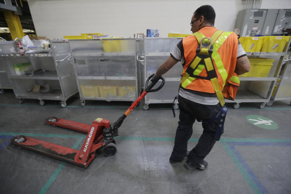 FILE - An employee pulls a pallet jack at the Amazon Fulfillment center in Robbinsville Township, N.J., Tuesday, Aug. 1, 2017. Amazon failed to properly record work-related injuries at warehouses located in five states, a federal agency said Friday, Dec. 16, 2022, while announcing it issued more than a dozen citations during the course of its ongoing investigation of the company. (AP Photo/Julio Cortez, File)