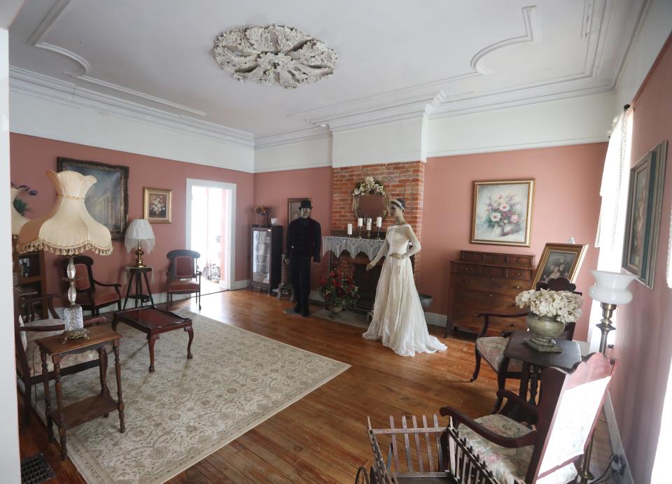 The living room of the Nelson T. Gant House has period appropriate displays of furniture and clothing.