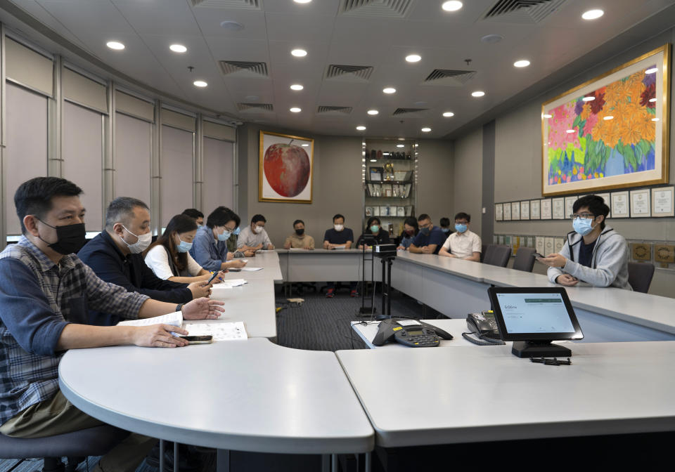 Reporters attend an editorial meeting at the news room of Apple Daily Monday, April 26, 2021, in Hong Kong. A year ago, the pro-democracy Apple Daily newspaper published a front-page headline saying Hong Kong's governing principle of “one country, two systems is dead." On Thursday, June 17, 2021, the newspaper was facing its greatest peril. Three top editors and two senior executives were arrested under Hong Kong's new national security law. (AP Photo/Vincent Yu)