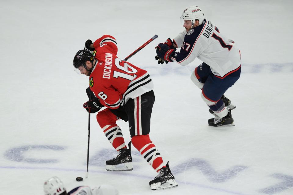 Chicago Blackhawks' Jason Dickinson (16) moves the puck against Columbus Blue Jackets' Justin Danforth (17) during the first period of an NHL hockey game Saturday, March 2, 2024, in Chicago. (AP Photo/Paul Beaty)