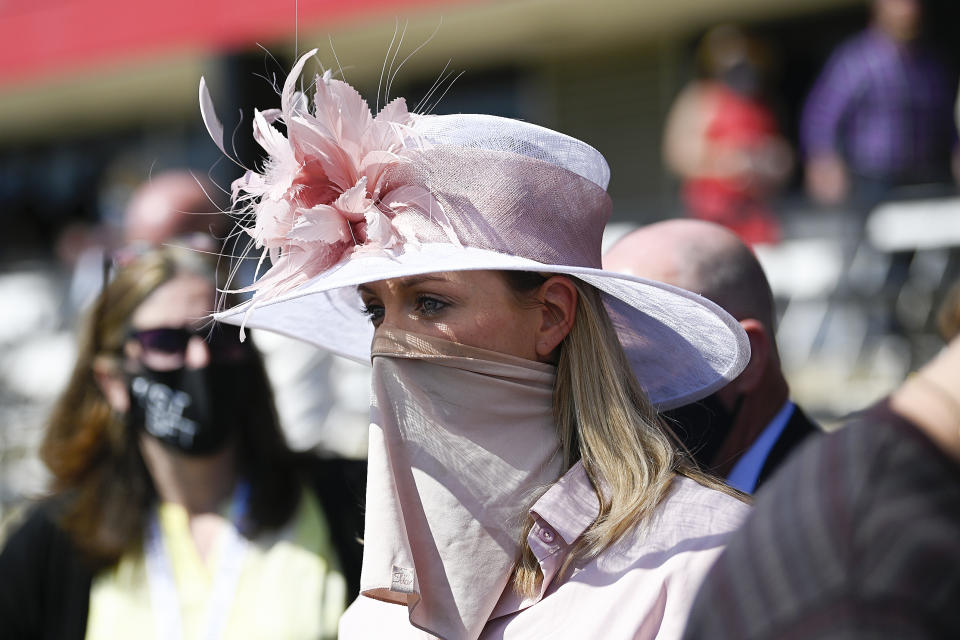 A woman wears a face covering to protect against the spread of COVID-19 during the Preakness Stakes horse race at Pimlico Race Course, Saturday, May 15, 2021, in Baltimore. (AP Photo/Nick Wass)