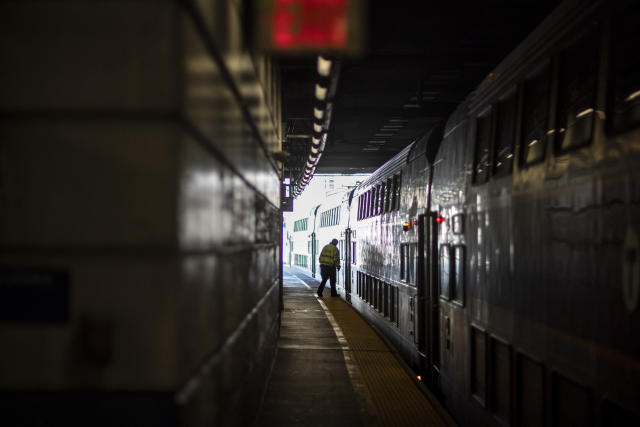 A train employee boards the commuter rail heading to Boston after waiting for passengers, Friday, Nov. 20, 2020, in Providence, R.I. With the coronavirus surging out of control, the nation's top public health agency pleaded with Americans not to travel for Thanksgiving and not to spend the holiday with people from outside their household. (AP Photo/David Goldman)