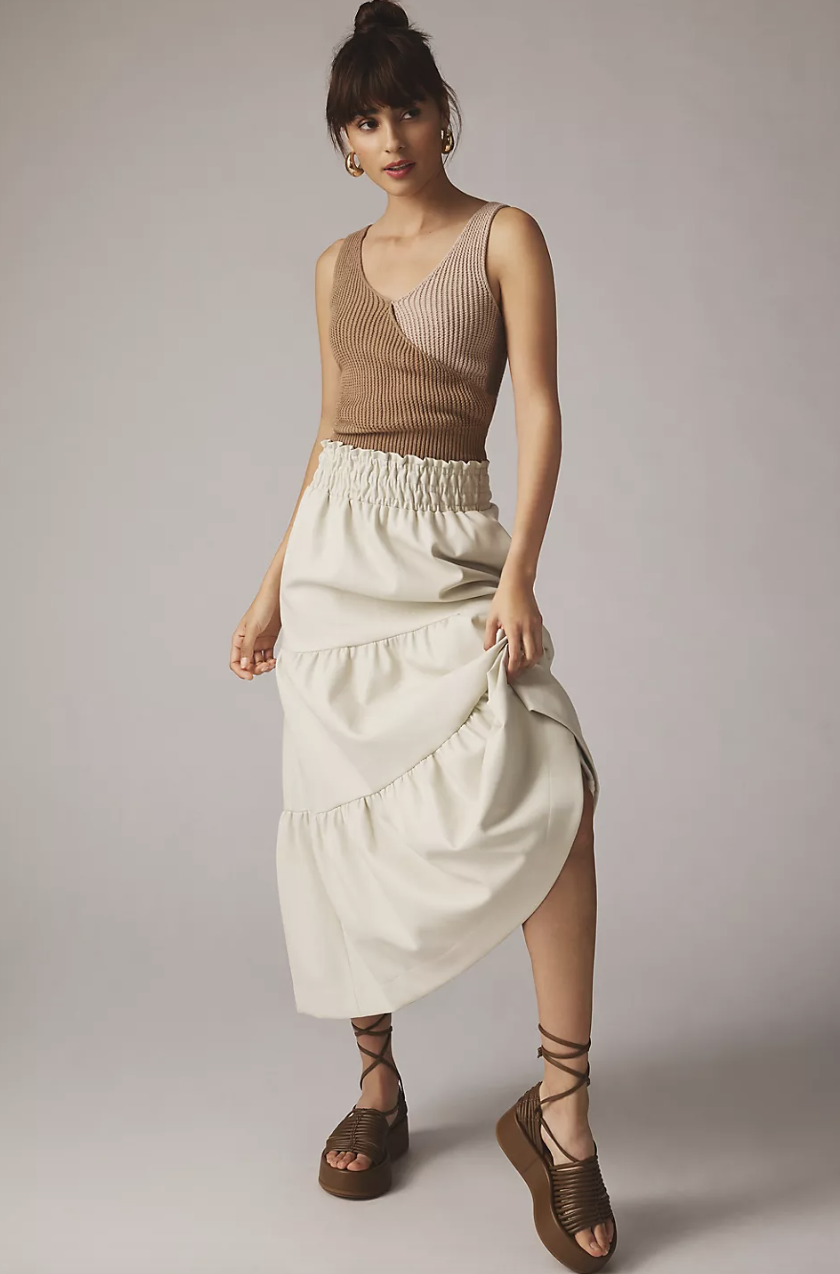 brunette woman in brown tank top and white The Somerset Maxi Skirt: Faux Leather Edition in white (photo via Anthropologie)