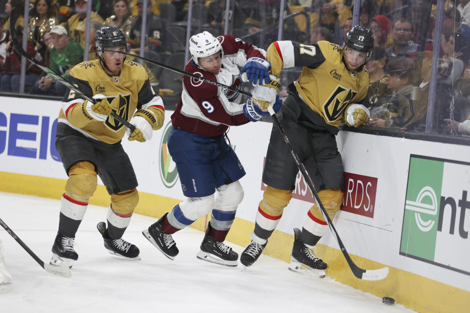 Vegas Golden Knights defenseman Zach Whitecloud (2) watches as Colorado Avalanche left wing Zach Parise (9) pushes Golden Knights defenseman Ben Hutton (17) during the third period of an NHL hockey game Sunday, April 14, 2024, in Las Vegas. (AP Photo/Ian Maule)