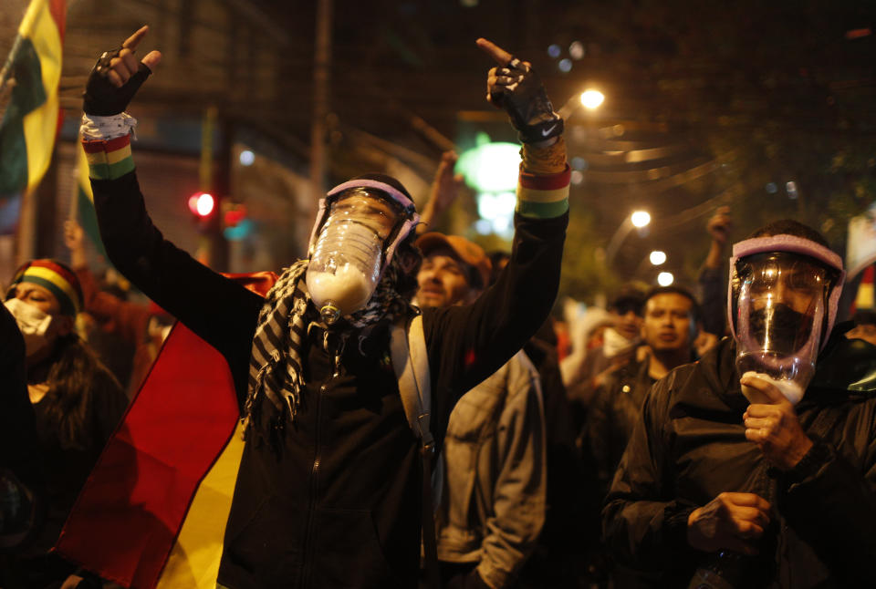 Anti-government demonstrators wearing home-made gas masks protest early presidential election results outside the administrative offices of the Supreme Electoral Court in La Paz, Bolivia, Tuesday, Oct. 22, 2019. International election monitors expressed concern over Bolivia's presidential election process Tuesday after an oddly delayed official quick count showed President Evo Morales near an outright first-round victory — even as a more formal tally tended to show him heading for a risky runoff. (AP Photo/Juan Karita)