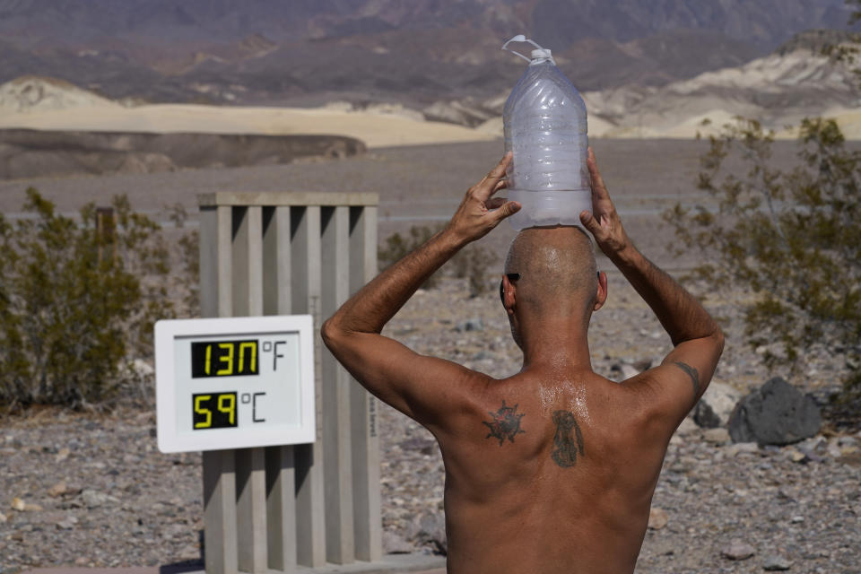FILE - In this Aug. 17, 2020, file photo, Steve Krofchik cools off with a bottle of ice water on his head in Death Valley National Park, Calif. Climate-connected disasters seem everywhere in the crazy year 2020. But scientists Wednesday, Sept. 9, say it'll get worse. (AP Photo/John Locher, File)