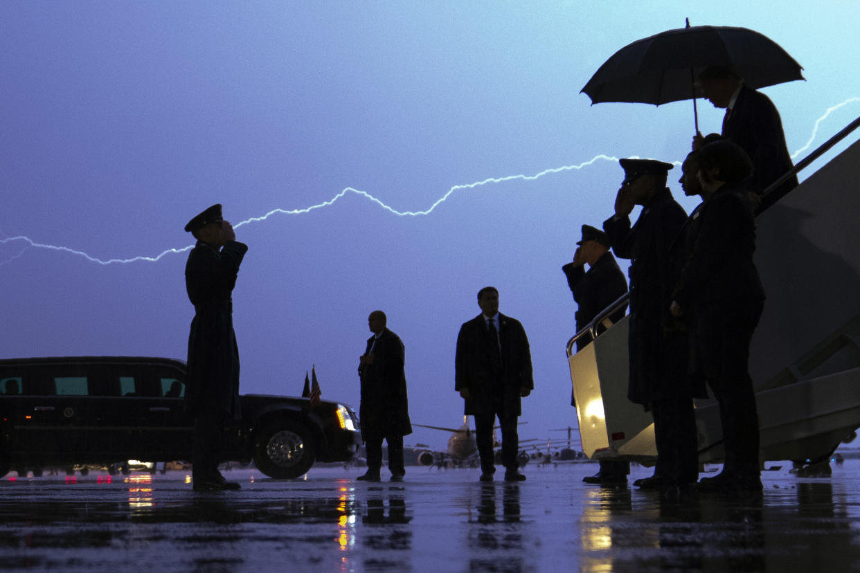 Lightning streaks across the sky as President Donald Trump walks from Air Force One carrying an umbrella as he arrives at Andrews Air Force Base in Maryland after a campaign rally in late August. A poll of subscribers to the Military Times shows him trailing Democrat Joe Biden.  (Photo: ASSOCIATED PRESS)