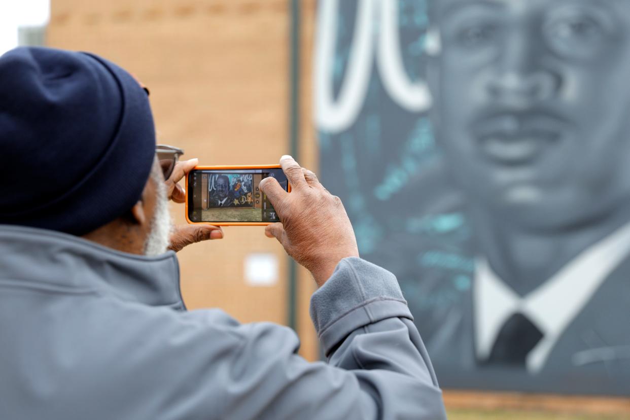Lloyd Davis takes a photo of a new mural in honor of his cousin Capt. Riley Leroy Pitts during a mural unveiling at Pitts Park in Oklahoma City, Saturday, Nov. 11, 2023.