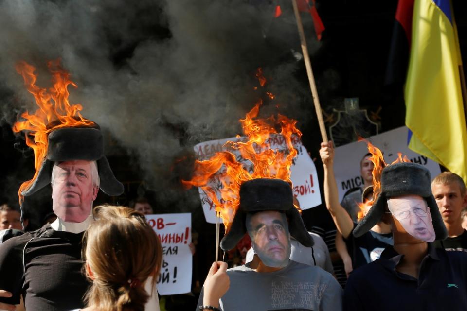 An activist sets on fire dummies of  Viktor Shokin and his two deputies during an anti-corruption rally near the Prosecutor General’s office in Kiev, Ukraine, on  July 24, 2015.  